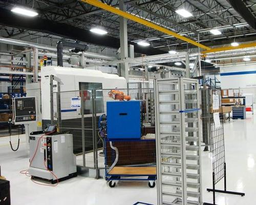 Interior of Turbomeca TMM Manufacturing Facility. Machinery in large industrial room with florescent lighting.